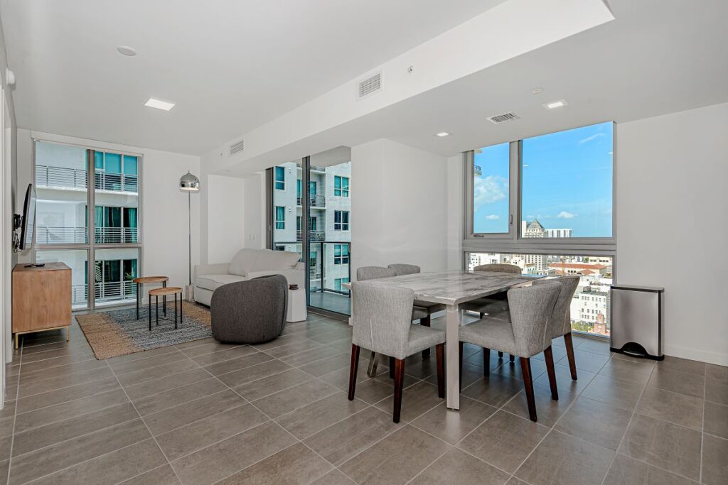 Living and dining with floor-to-ceiling city windows